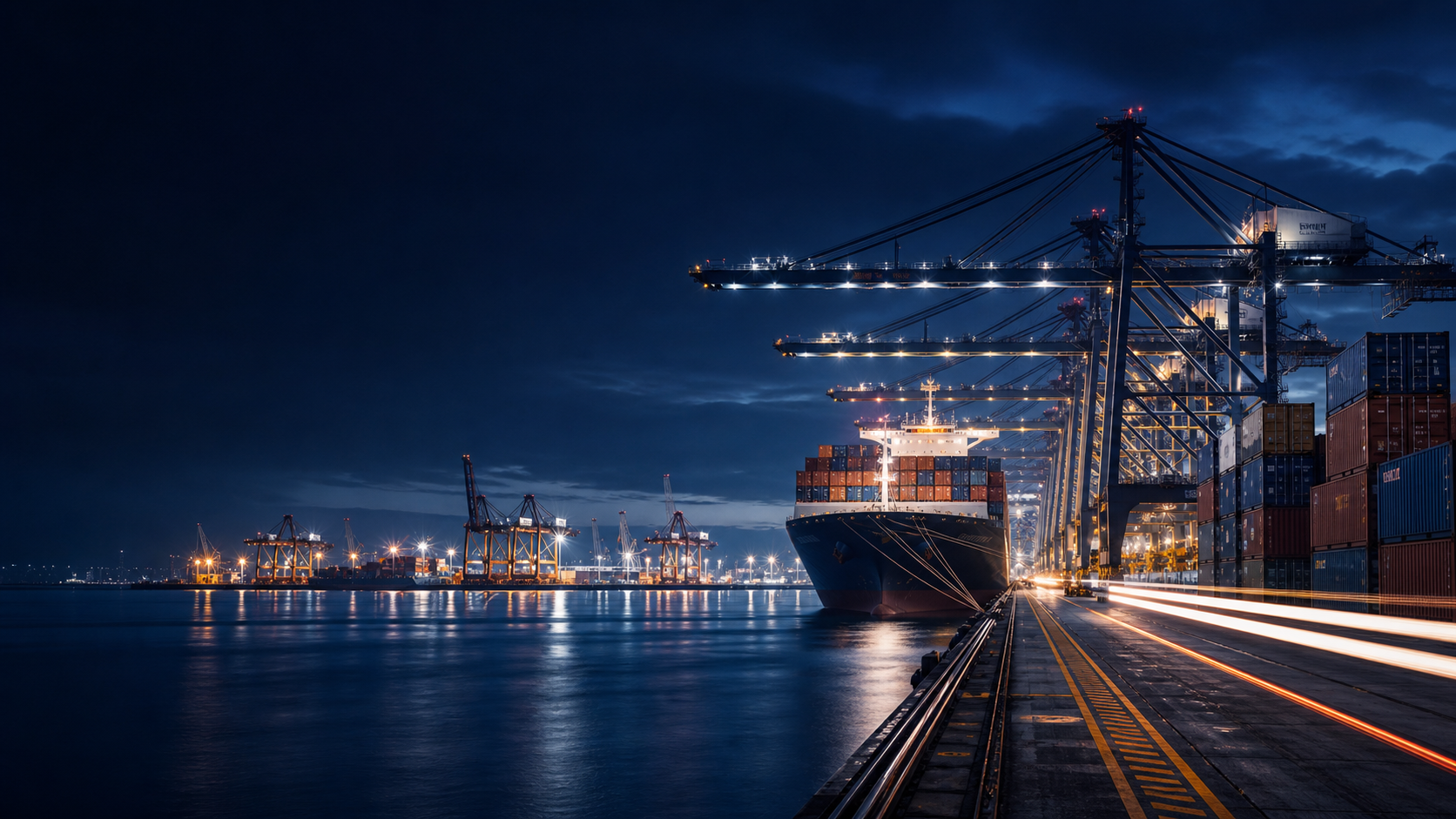 Night container port with cranes and cargo ship